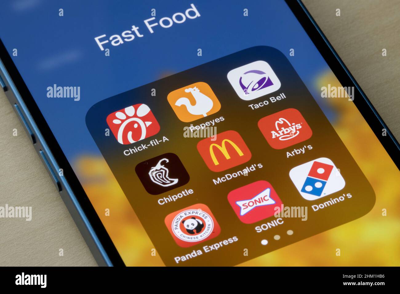 Auf einem iPhone sind verschiedene Fast-Food-Ketten-Apps zu sehen: Chick-Fil-A, Popeyes, Taco Bell, Chipotle, McDonald's, Arby's, Panda Express, SONIC und Domino's.. Stockfoto