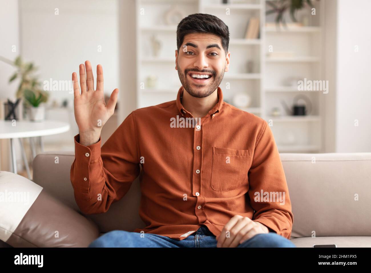 Grußkonzept. Arabischer Mann winkt Hand an Kamera Stockfoto