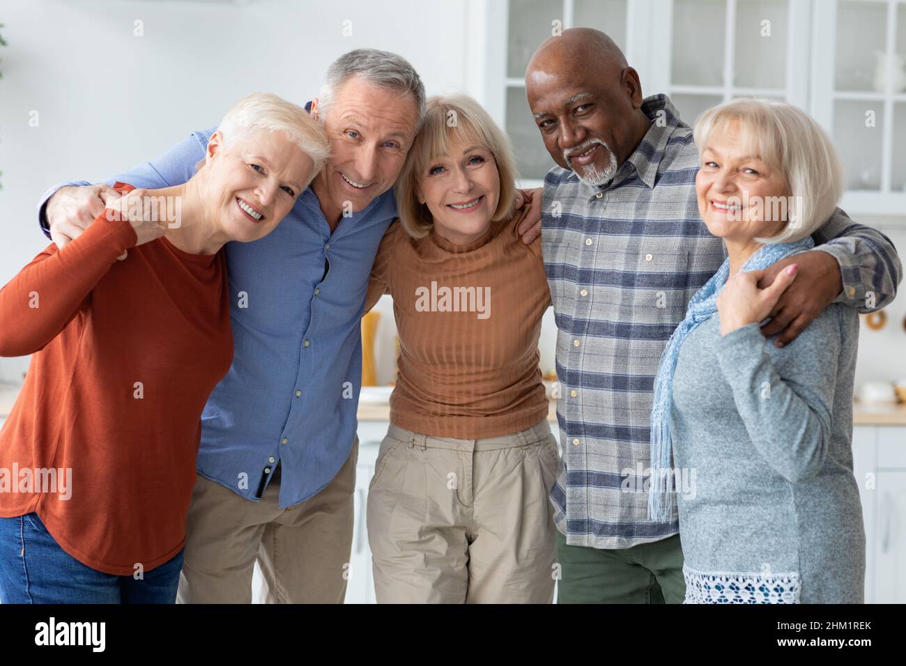 Gruppenfoto von glücklichen älteren Menschen, die sich umarmen und die Kamera lächeln Stockfoto