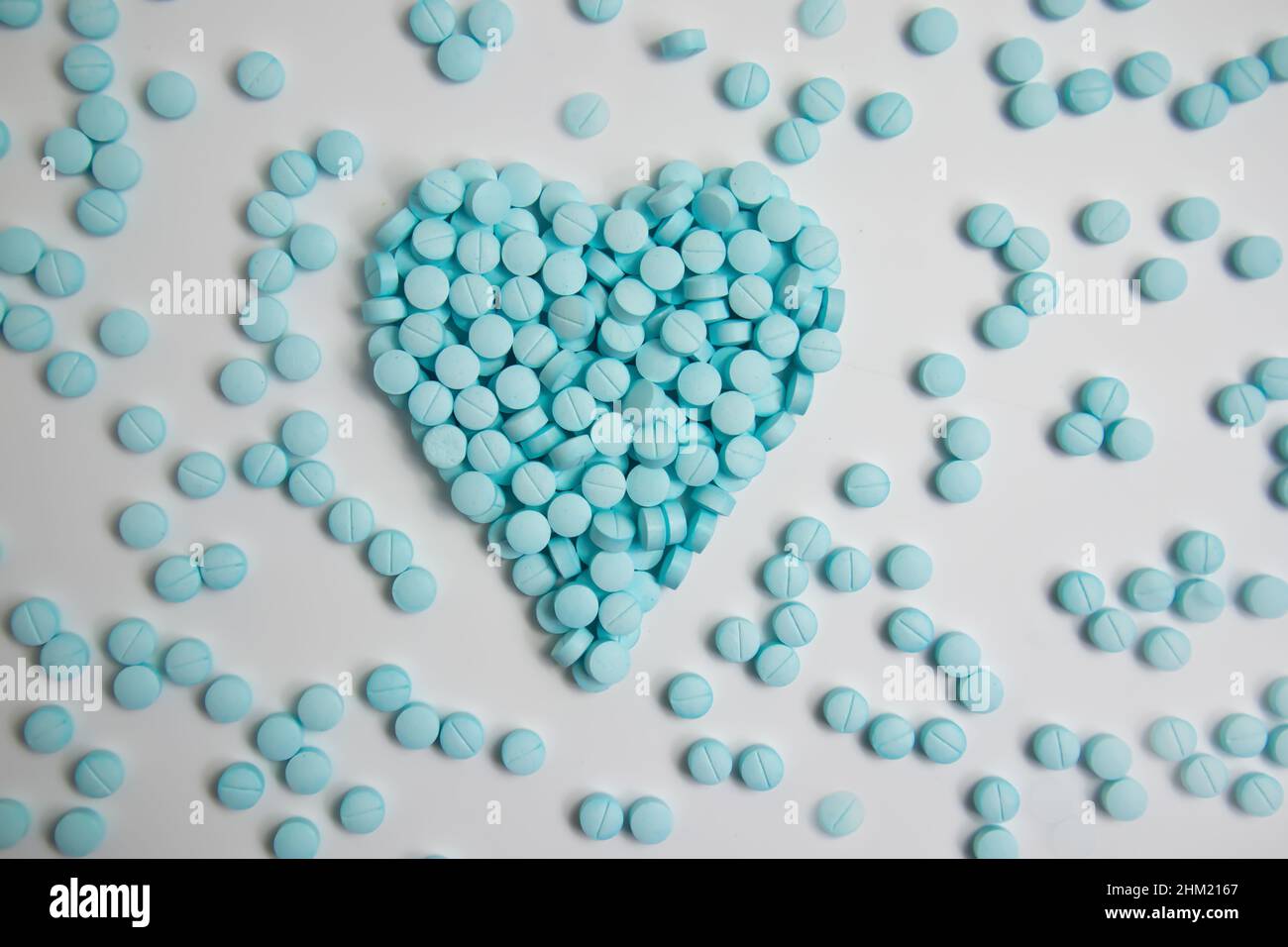 Herz aus blauen Pillen auf weißem Hintergrund isoliert Stockfoto