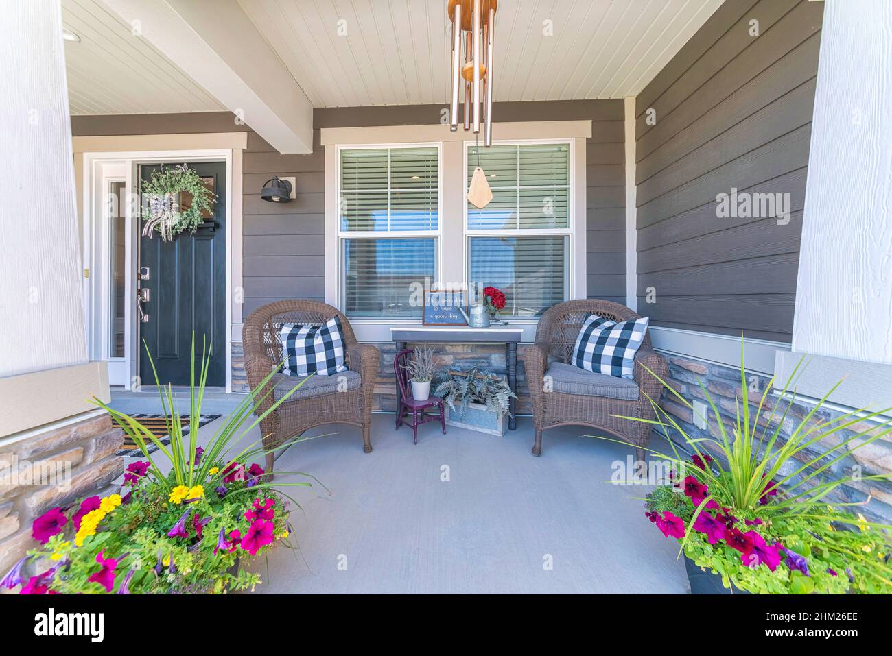Schöne Veranda mit Topfblumen und zwei gewebten Sesseln Stockfoto