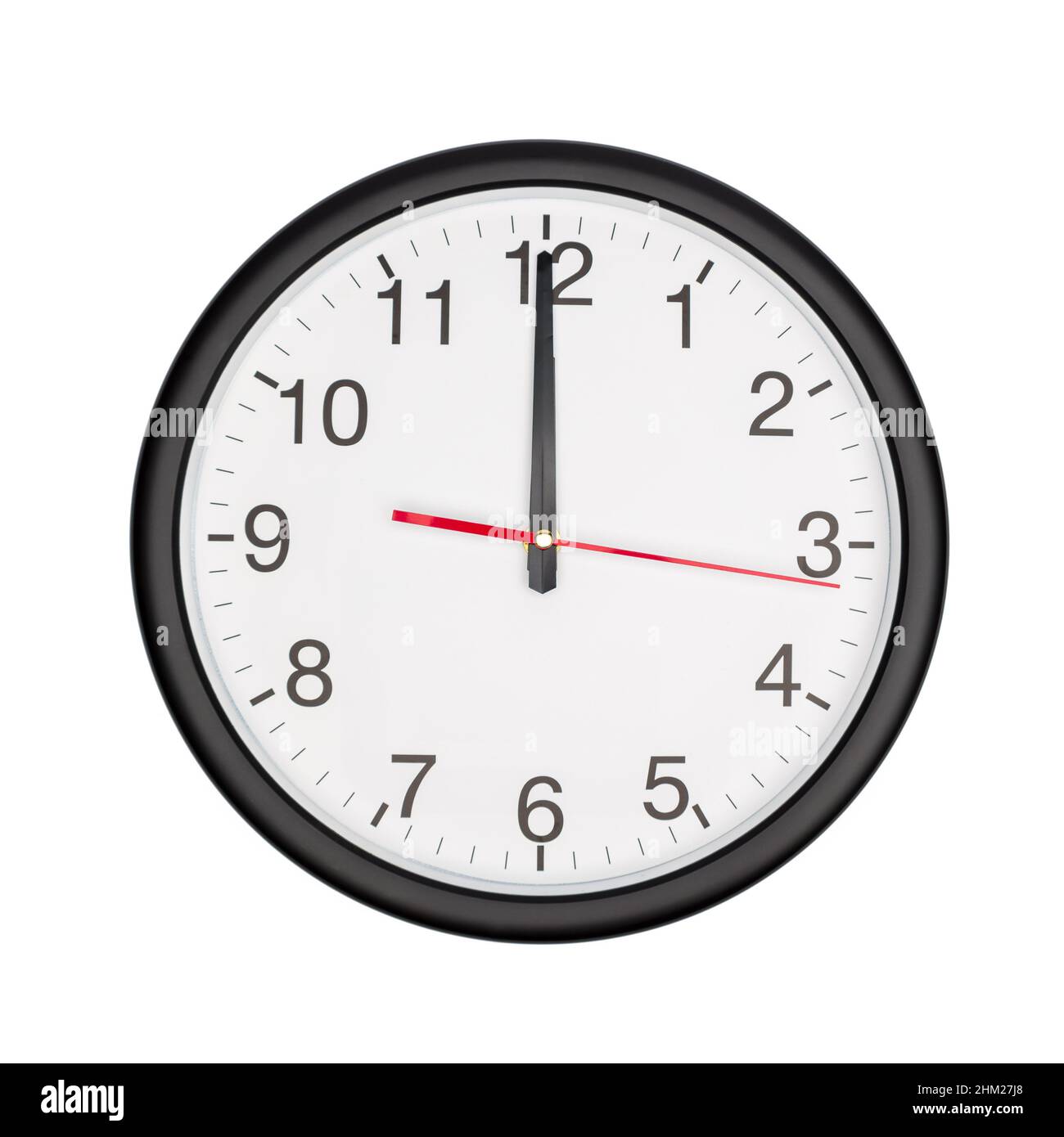 Die klassische schwarze Uhr an der runden Wand zeigt Mitternacht Stockfoto