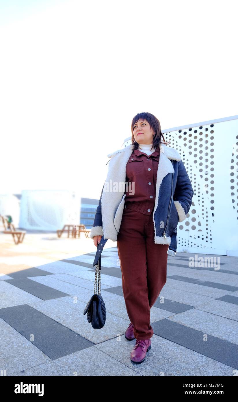 Frau aus der Mitte der dreißiger Jahre, die in einer großen Stadt unterwegs ist. Stockfoto