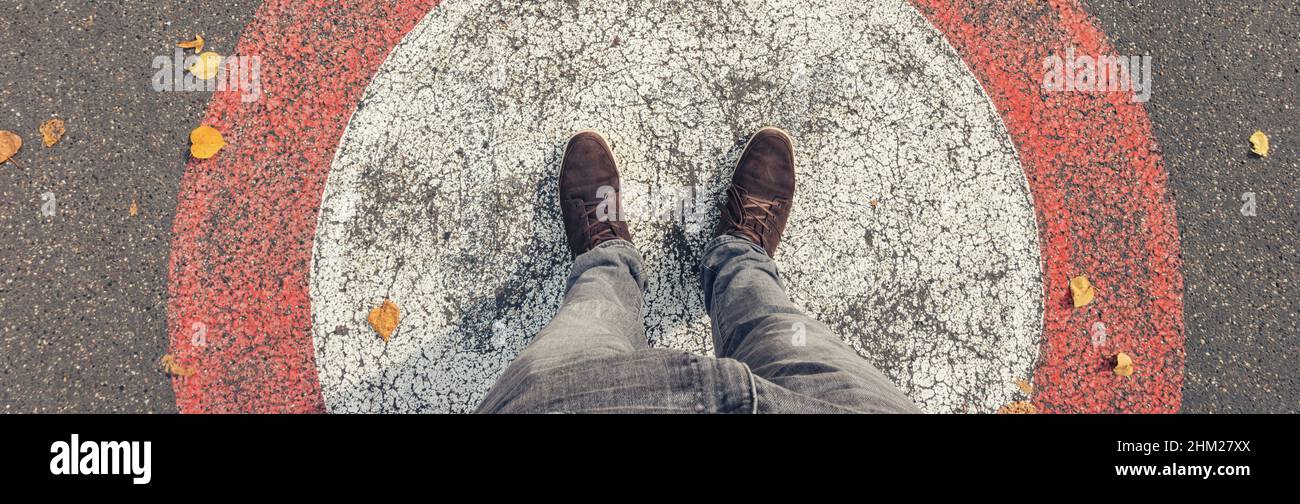 Man in steht in einem Kreis mit roter Linie auf den Straßen, persönliche Pespative von oben. Stockfoto