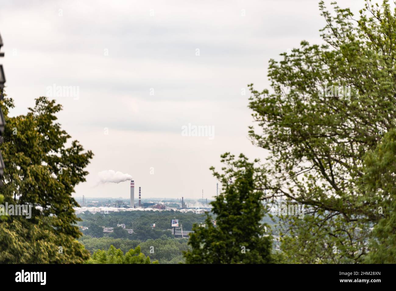 Der Park und die Produktion stehen am Horizont. Die Fabrik rohren durch das Laub der Bäume in Bratislava. Stockfoto