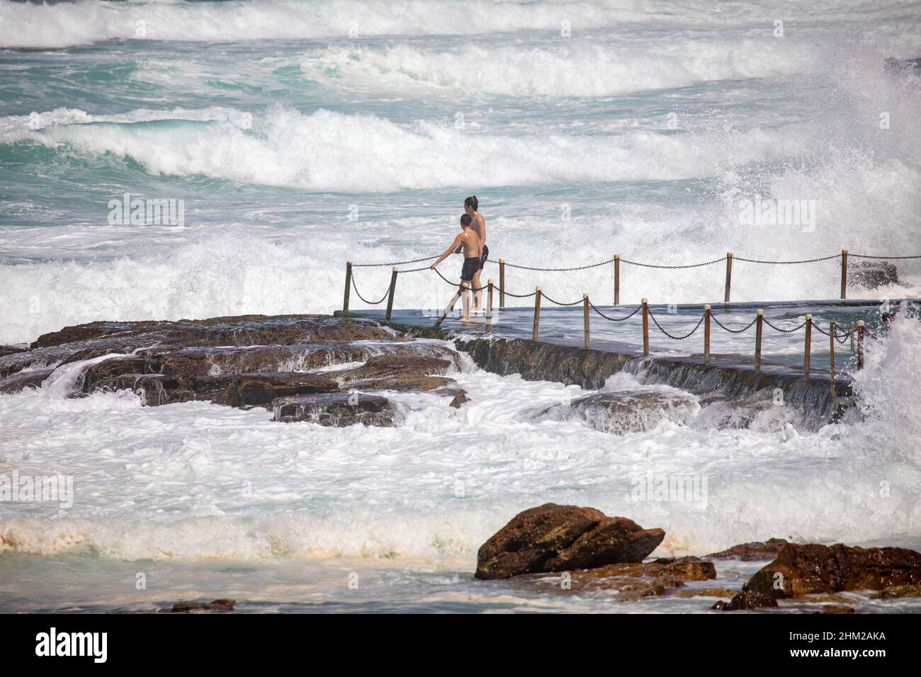 Jugendliche spielen in der Meeresbrandung am Avalon Beach Ocean Rock Pool in Sydney, NSW, Australien Stockfoto