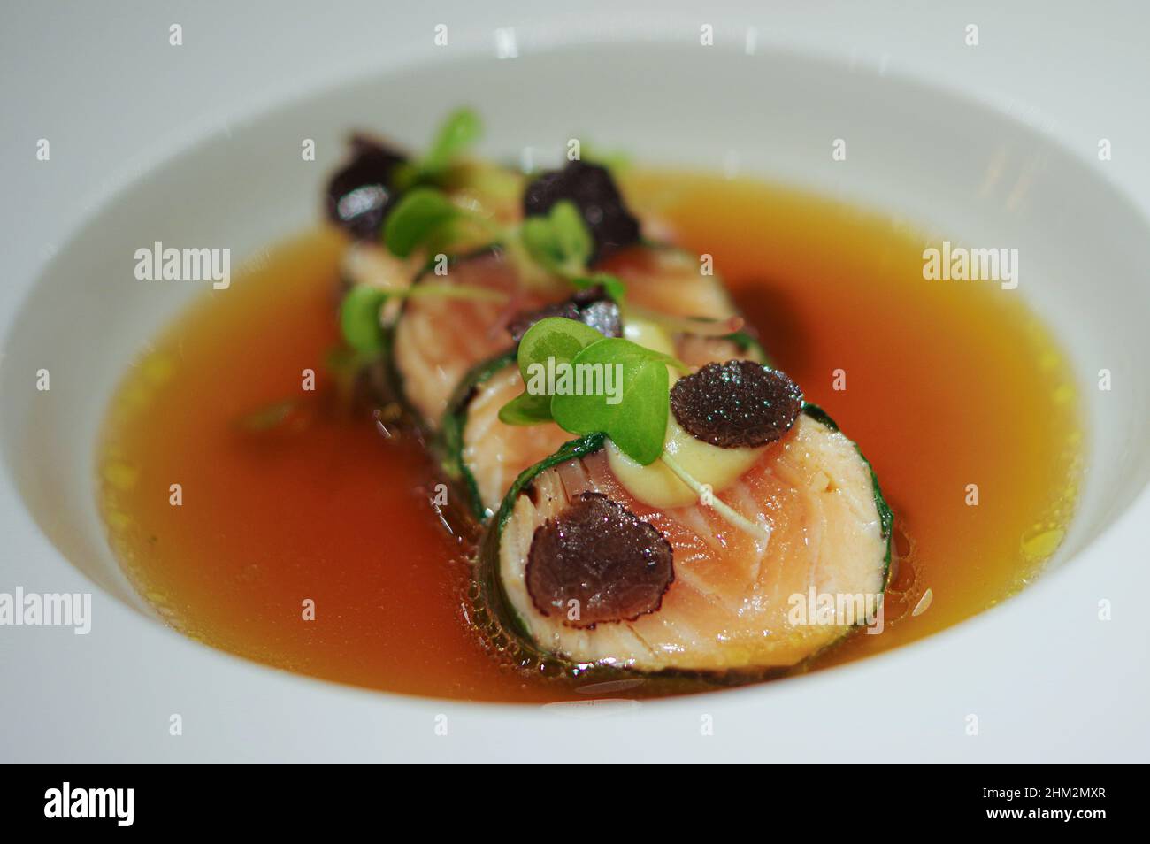Nori wickelte Lachsrolle mit geschnittenen schwarzen Trüffeln und Sprossen in Suppenschüssel Stockfoto