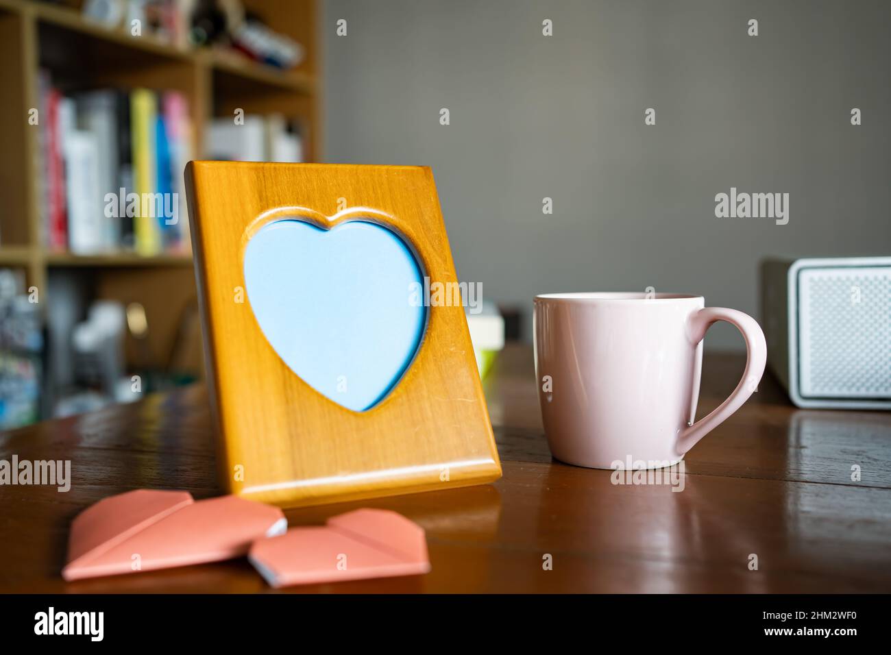 Herzförmiger Bilderrahmen aus Holz auf einem Arbeitstisch Stockfoto