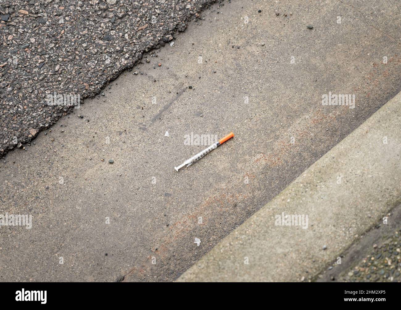 Heroin und Drogenmissbrauch in der Innenstadt von VancouverÕs East Side. In der Rinne neben einem Straßenrand in der Innenstadt von Vancouver British liegt eine gebrauchte hypodermische Nadel Stockfoto