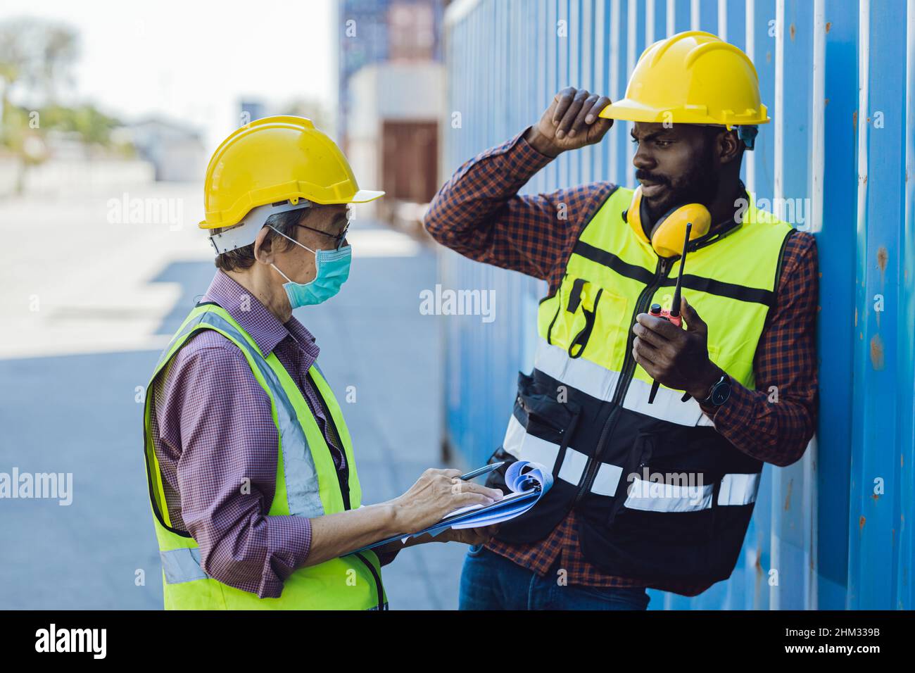 Älteres Personal, das mit einem jungen schwarzen afrikanischen Arbeiter zusammenarbeitet und miteinander spricht Stockfoto