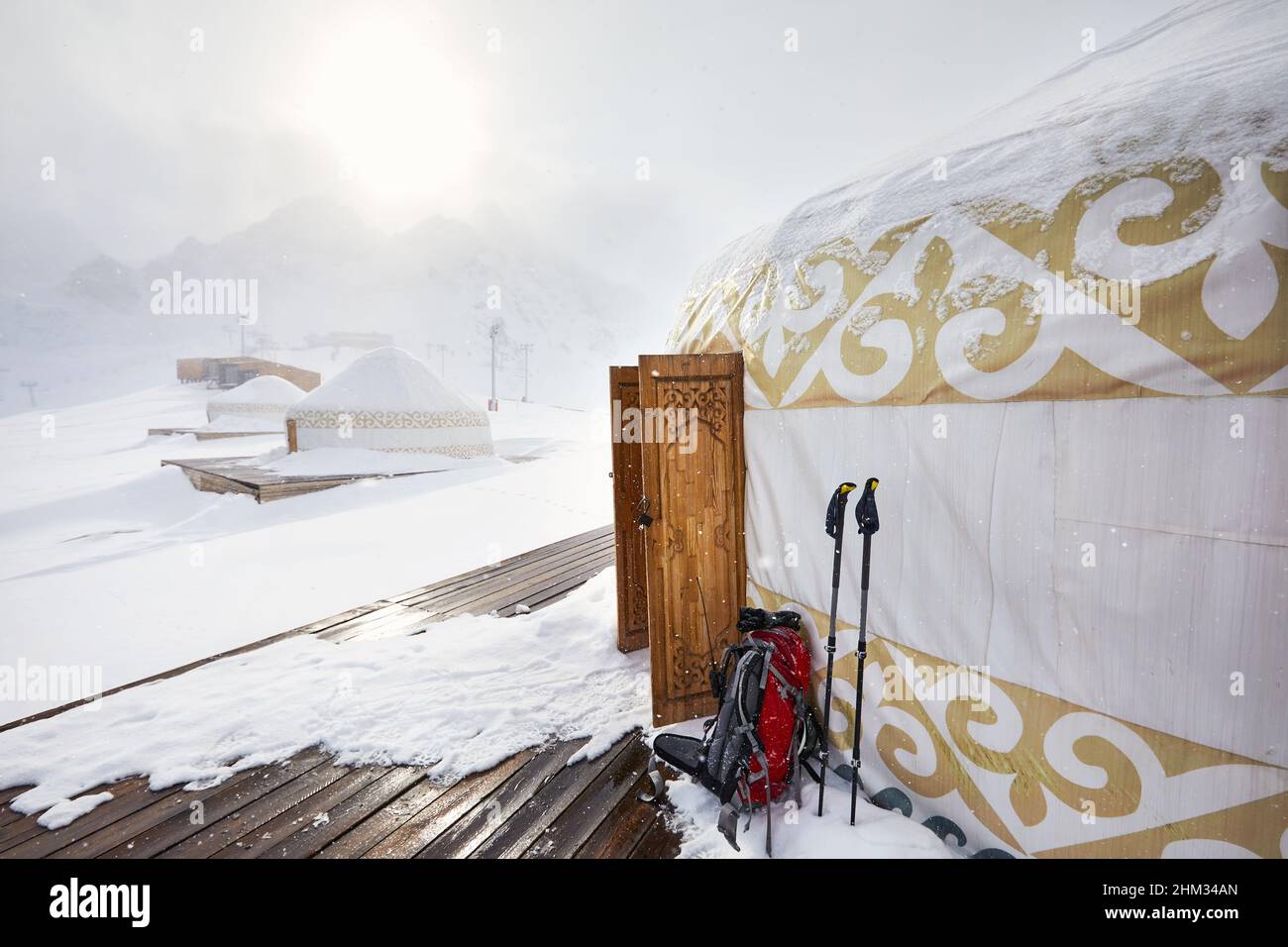 Hotel und Restaurant vom Yurt nomadischen Hauskomplex im Skigebiet Shymbulak in Almaty, Kasachstan. Öffnen Sie die Holztür mit ethnischem Muster im Winter sno Stockfoto