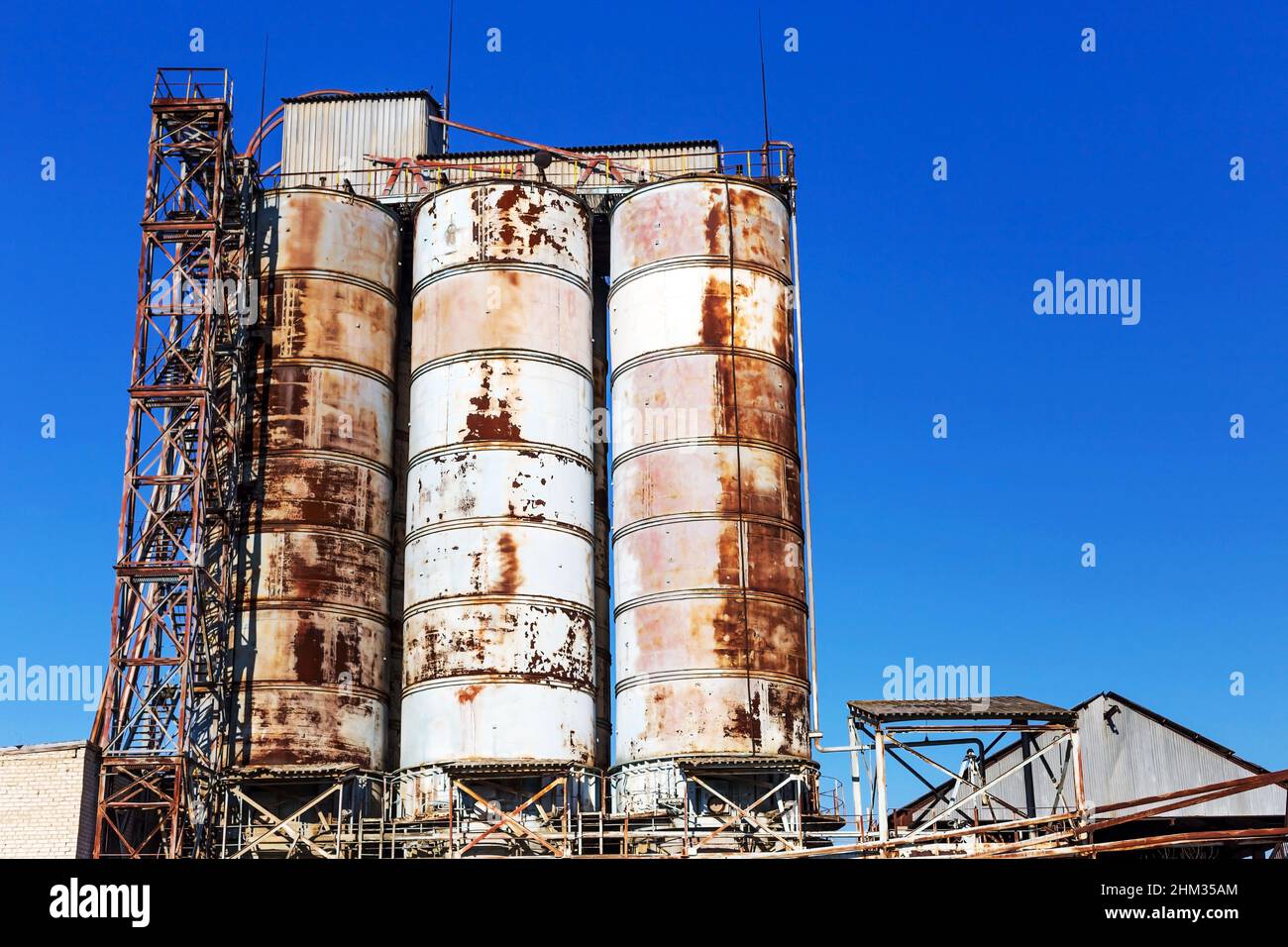 Alte, verlassene Betonanlage mit eisenverrosteten Tanks und Metallkonstruktionen. Die Krise, der Niedergang der Wirtschaft, die Produktionsstopps führten zur Krise Stockfoto