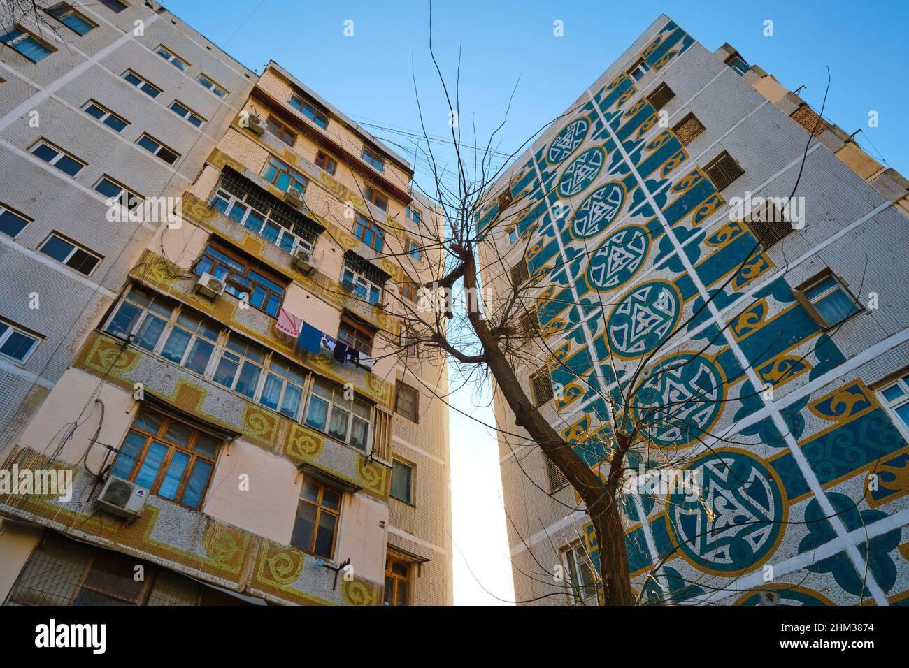 Sowjetische, russische, UdSSR, CCCP-Ära riesige Wandmalereien mit Mosaikfliesen an den Enden eines großen Mehrfamilienhauses. In Taschkent, Usbekistan. Stockfoto