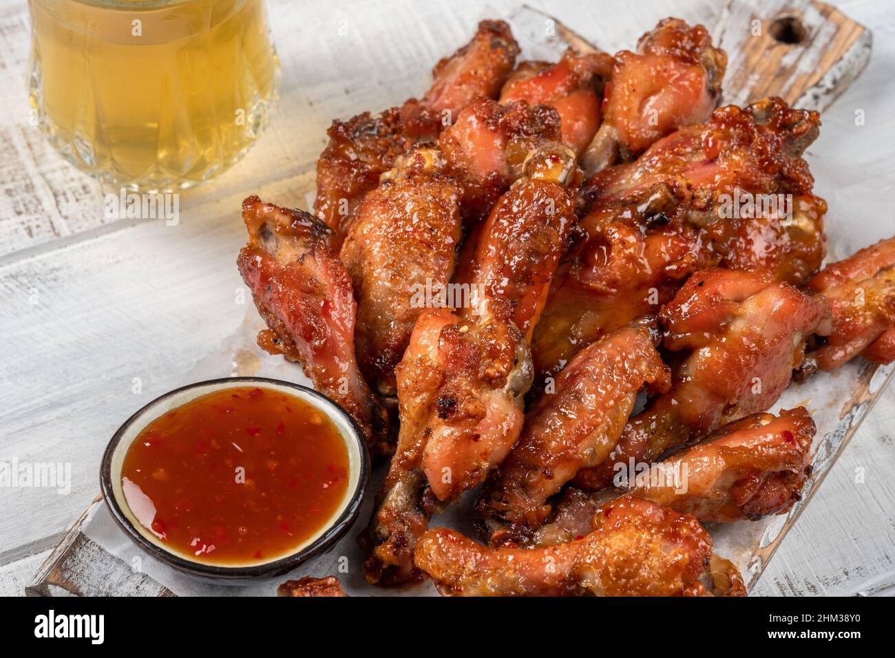 Hähnchenflügel mit Sriracha Sauce auf Holztisch Stockfoto