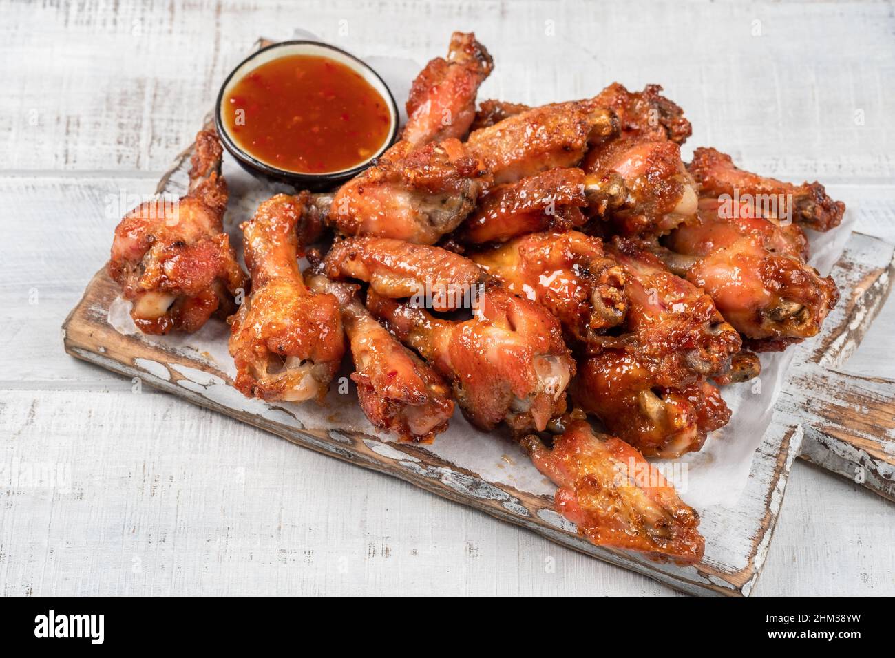 Hähnchenflügel mit Sriracha Sauce auf Holztisch Stockfoto