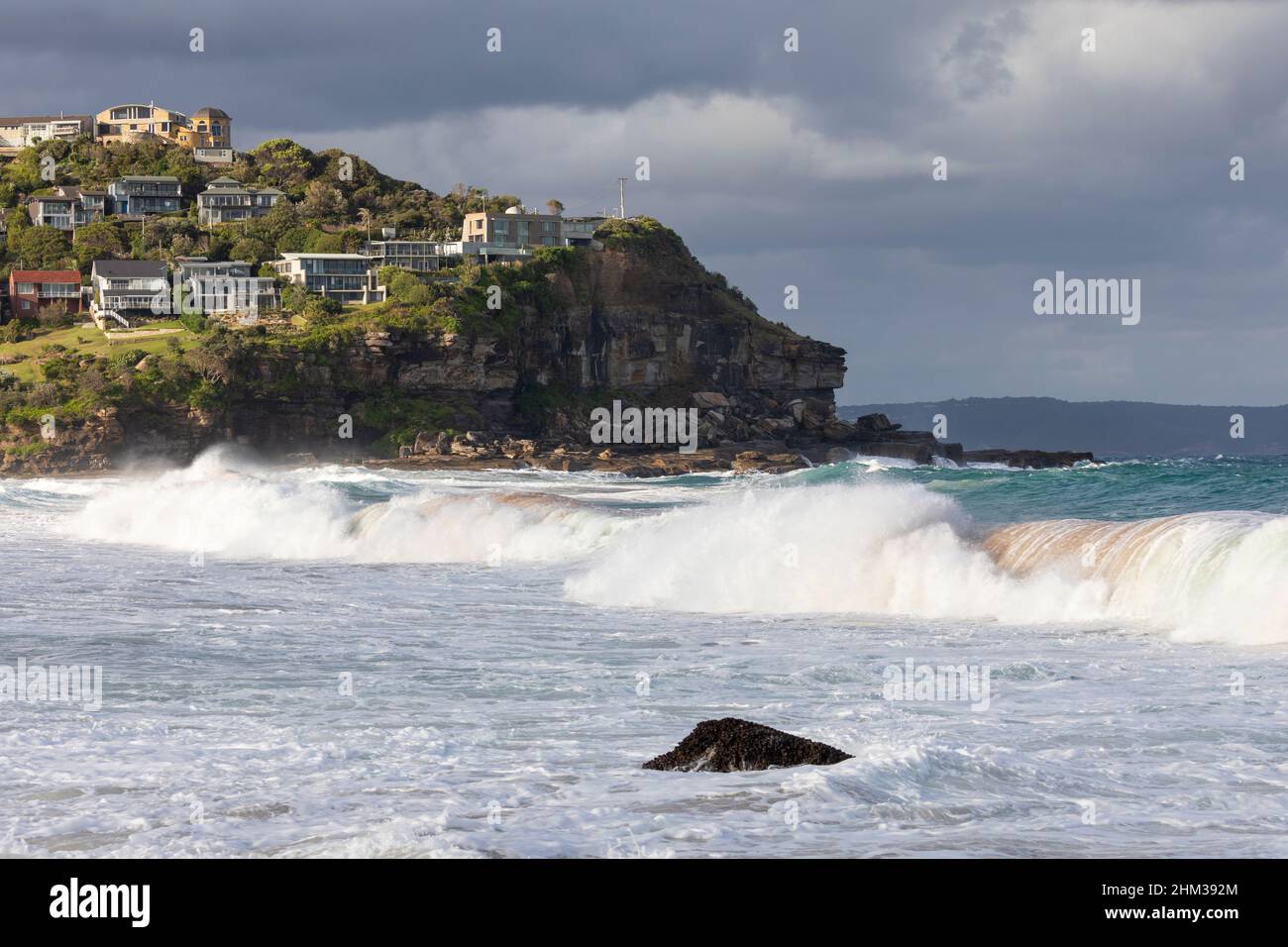 Whale Beach und Dolphin Bay mit Sonnenschein am späten Nachmittag auf der kleinen Landzunge, Häuser am Wasser, Sydney, NSW, Australien Stockfoto
