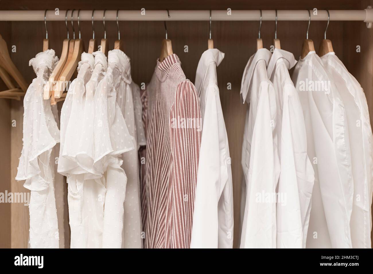 Kleidung im Schrank. Leichte Vintage-Damenbekleidung auf Kleiderbügeln im Schrank der Ankleidekabine. Modetrends, Textilien, Recycling, aus zweiter Hand. Hochwertige Fotos Stockfoto