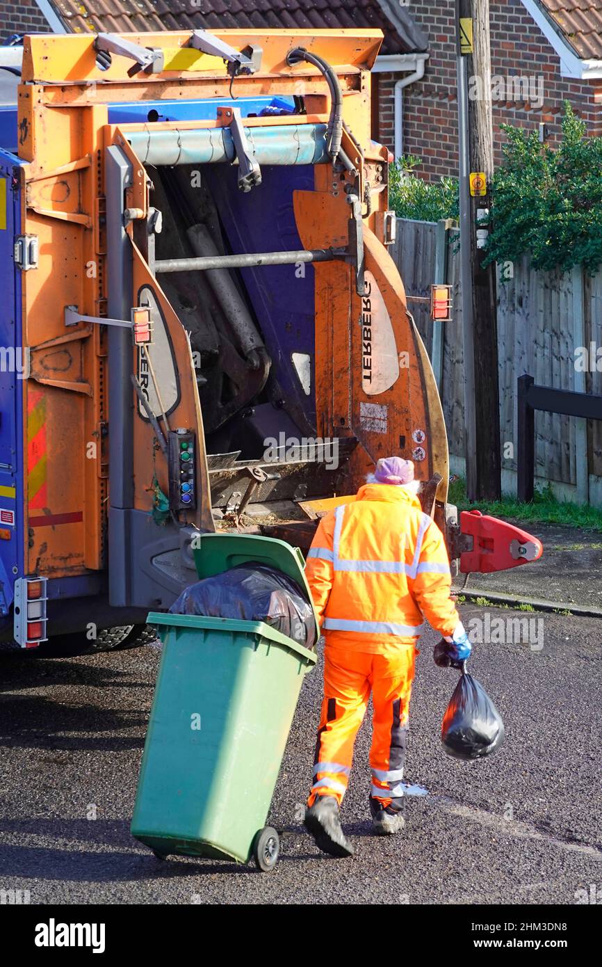 Müllmann Zuflucht Sammler Rückansicht in gut sichtbarer Kleidung ziehen Wheelie bin voller schwarzer Müllsäcke in LKW-LKW rat Dustcart UK Stockfoto