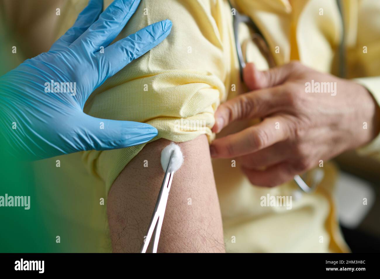 Krankenschwester, die nach der Injektion eines Impfstoffs gegen einen neuen Stempel des Coronavirus einen Wattebausch vor Ort einsetzte Stockfoto