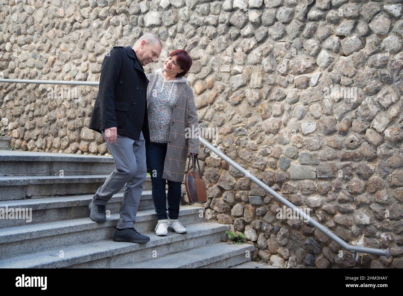 Ein älteres Paar, ein Mann und eine Frau, die die Treppe hinunter gingen und lachten Stockfoto