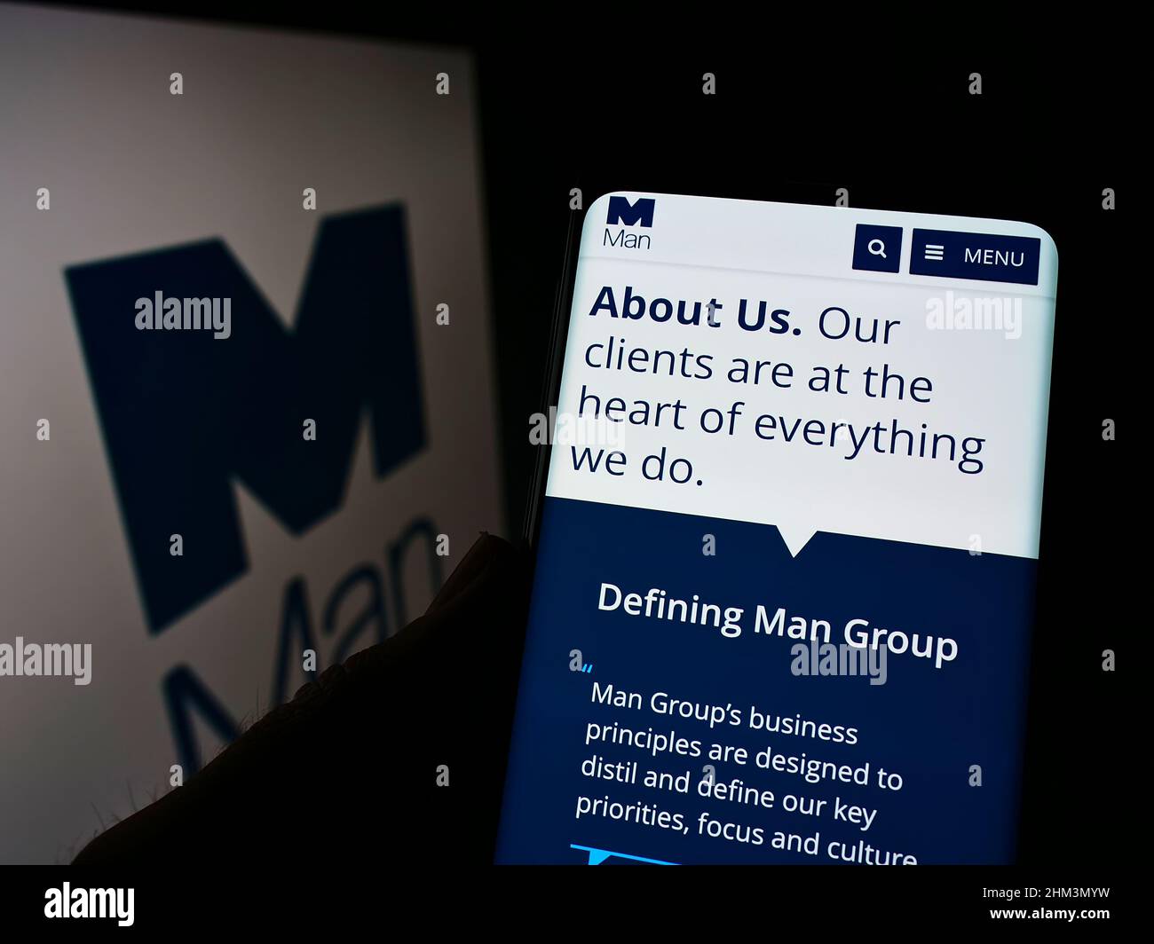 Person, die Mobiltelefon mit der Webseite des britischen Finanzunternehmens man Group plc auf dem Bildschirm vor dem Logo hält. Konzentrieren Sie sich auf die Mitte des Telefondisplays. Stockfoto