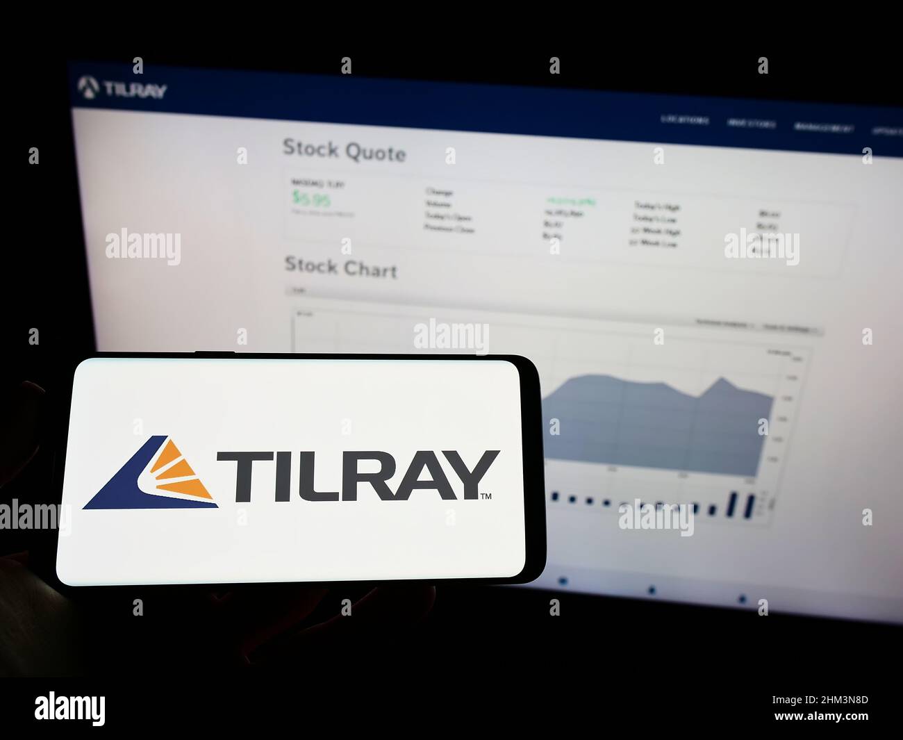 Person, die ein Mobiltelefon mit dem Logo des kanadischen Cannabisunternehmens Tilray Inc. Auf dem Bildschirm vor der Unternehmenswebseite hält. Konzentrieren Sie sich auf die Telefonanzeige. Stockfoto