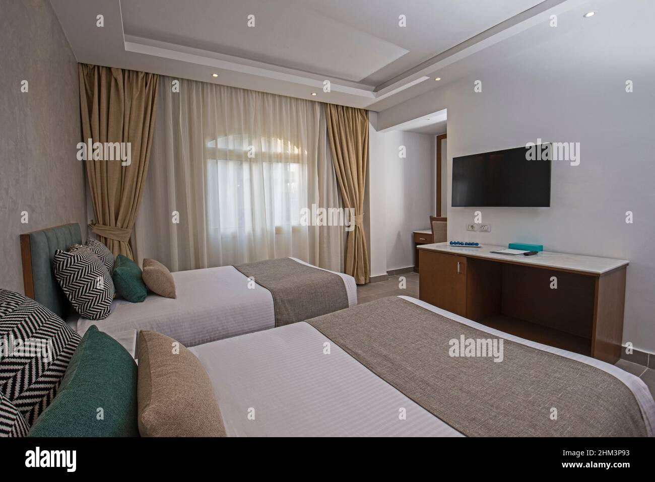 Twin-Betten in einer Suite eines luxuriösen Hotelzimmers mit modernen Möbeln im Innendekor Stockfoto