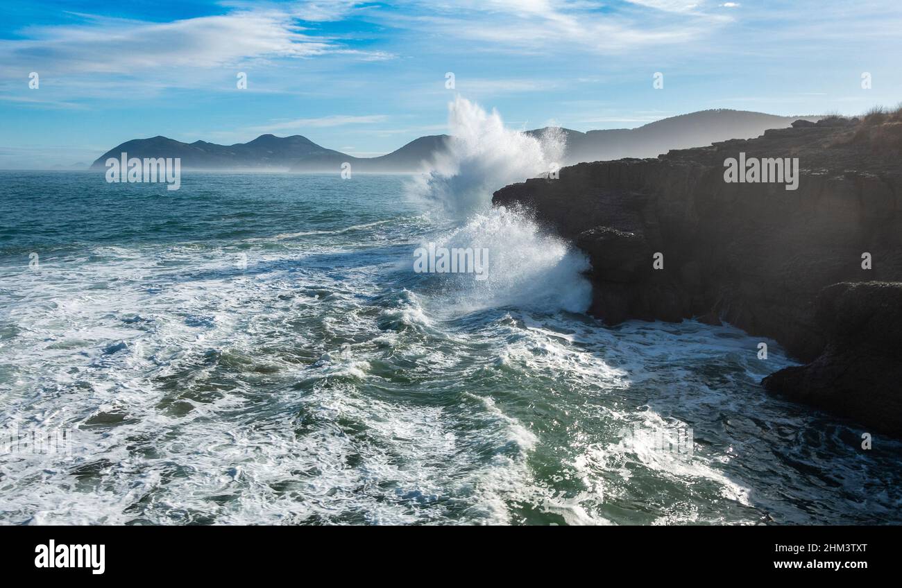 Krachende Wellen von Meeresstürmen gegen felsige Felswände in Noja, Kantabrien, Spanien Stockfoto