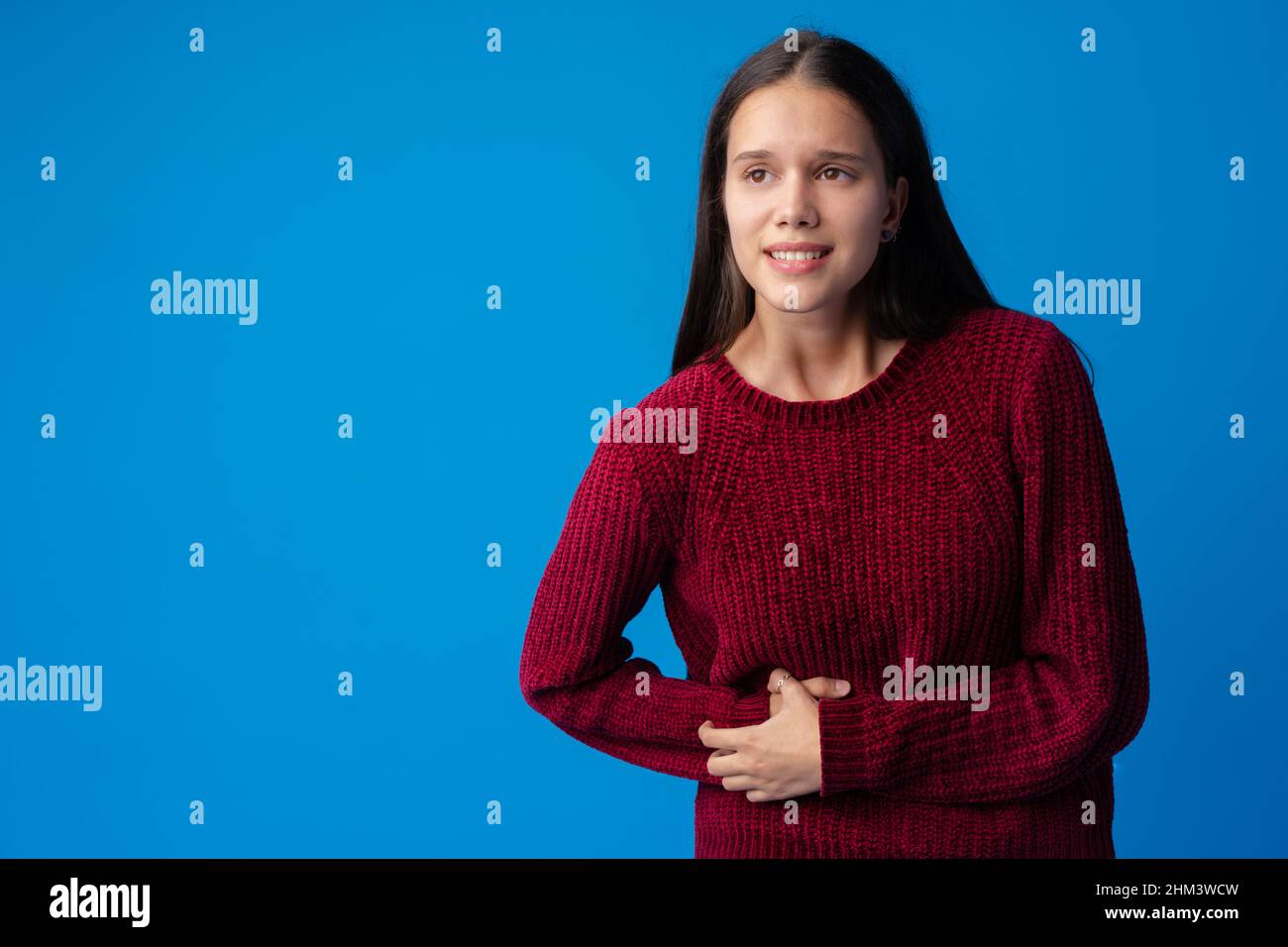 Junges Mädchen mit Bauchschmerzen isoliert auf blauem Hintergrund Stockfoto