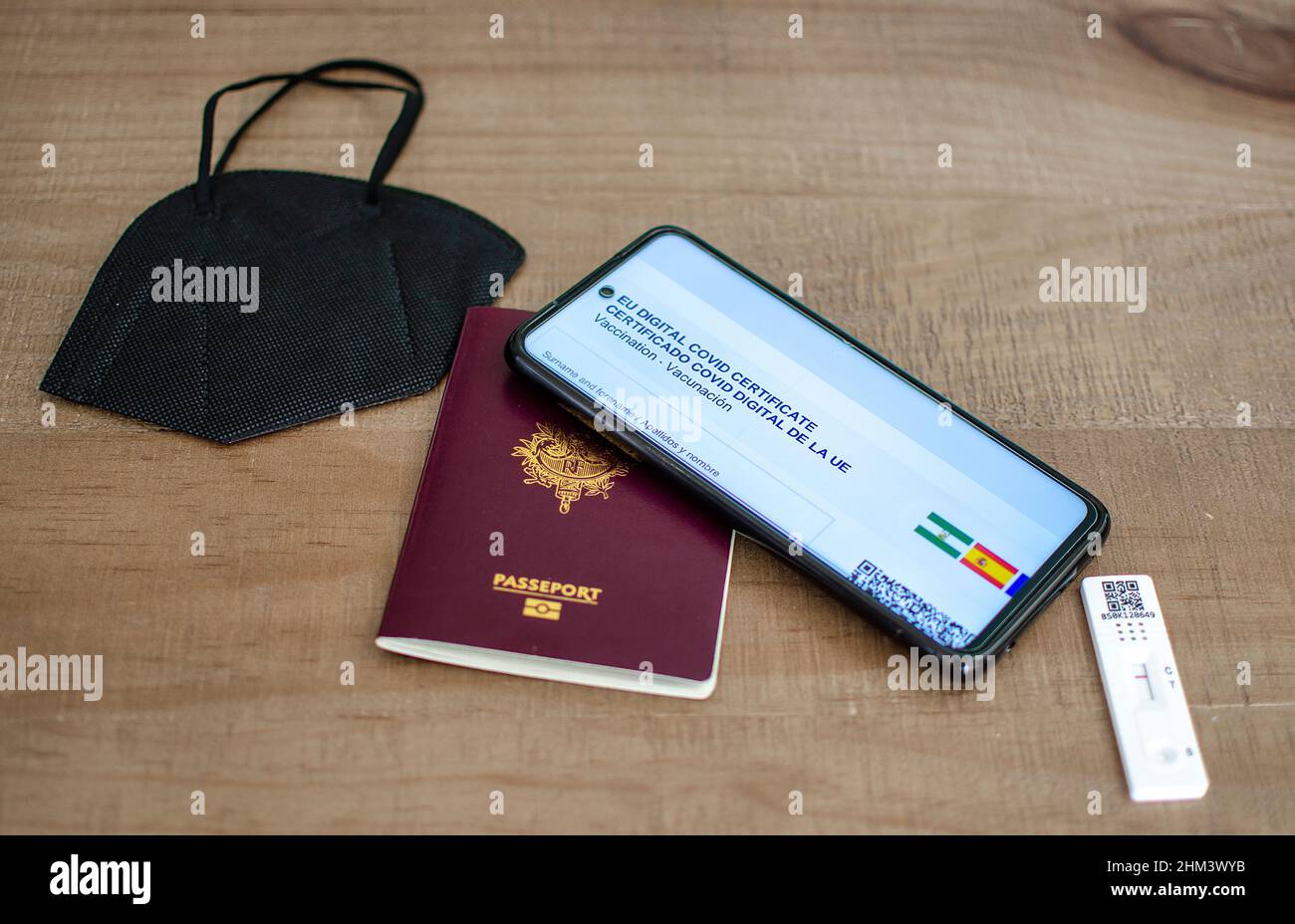Antigentest, Reisepass, EU Digital COVID Zertifikat und FFP2 Maske auf einem Holztisch. Neues Normal- und Reisekonzept. Stockfoto
