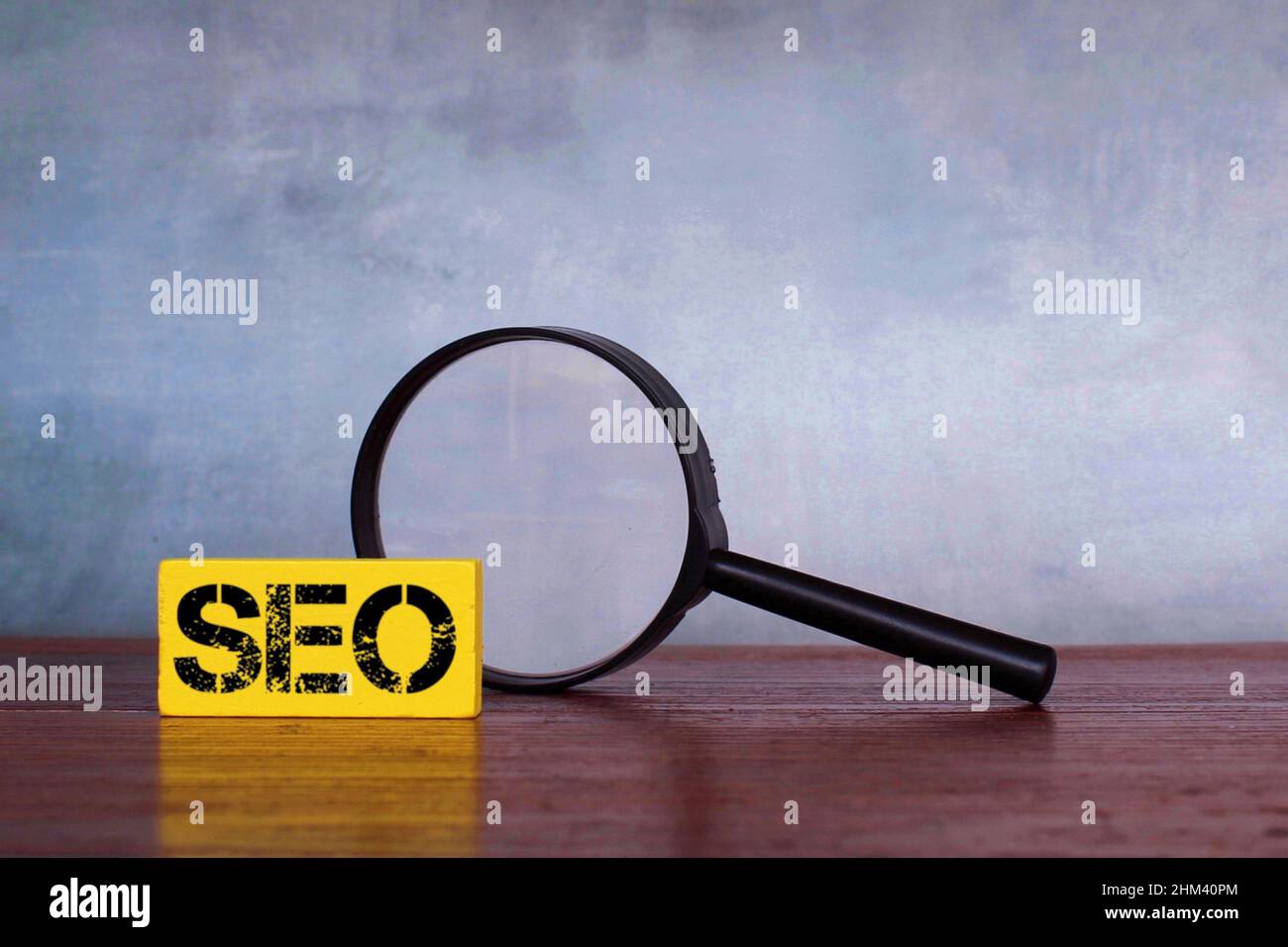 Konzept zur Suchmaschinenoptimierung. Lupe und Holzwürfel mit Text SEO oder Suchmaschinenoptimierung Stockfoto