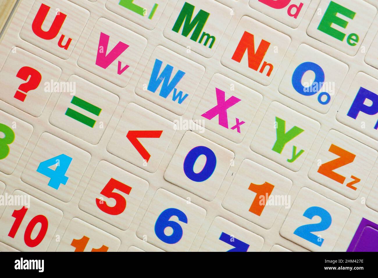 Bunte Plastikbuchstaben auf orangefarbenem Hintergrund, Draufsicht Stockfoto