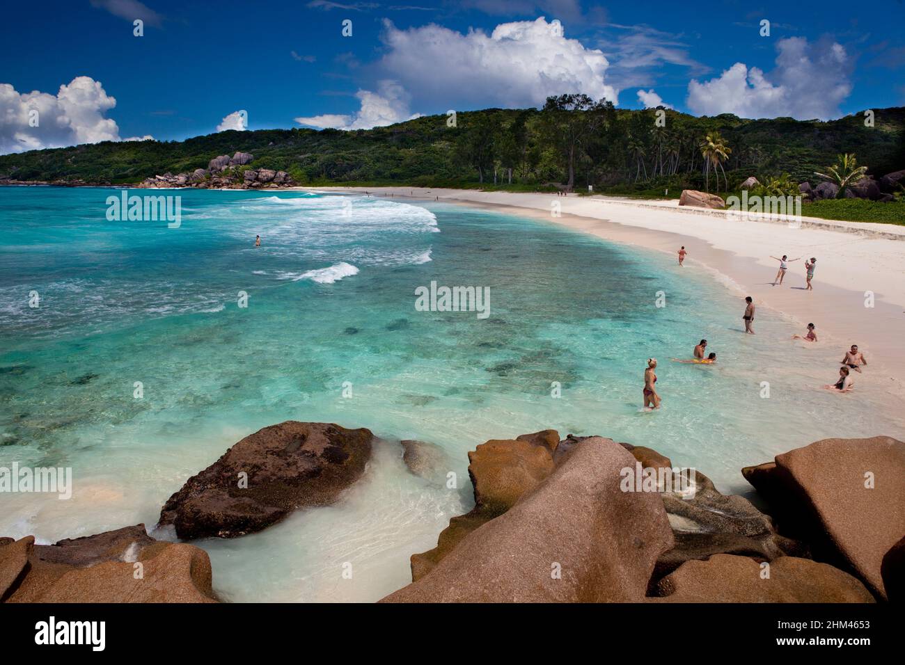 Touristen schwimmen am Grand Anse Beach auf der Insel La Digue, Seychellen. Stockfoto