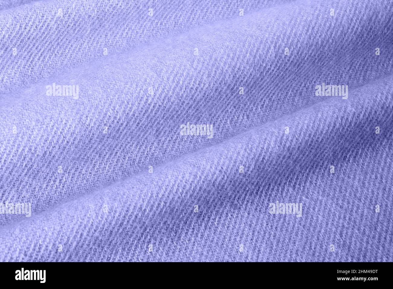 Violett gestrickte Acryl-Stoffstruktur mit weichem Faltenmuster. Farbtrend des Jahres 2022. Stockfoto