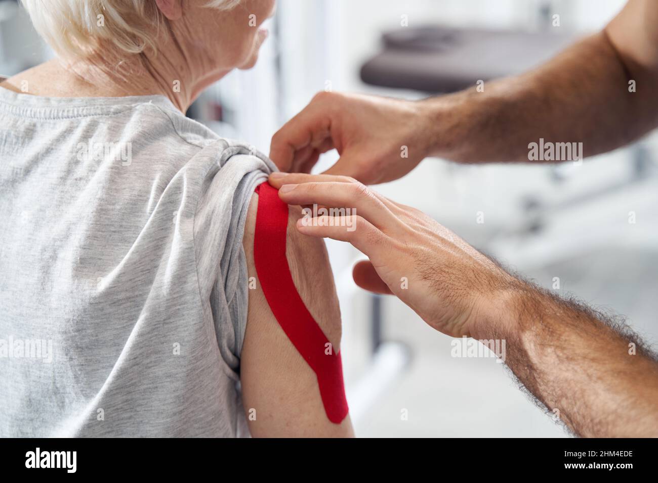 Medizinisches Personal lindert Armschmerzen mit elastischem therapeutischem Band Stockfoto