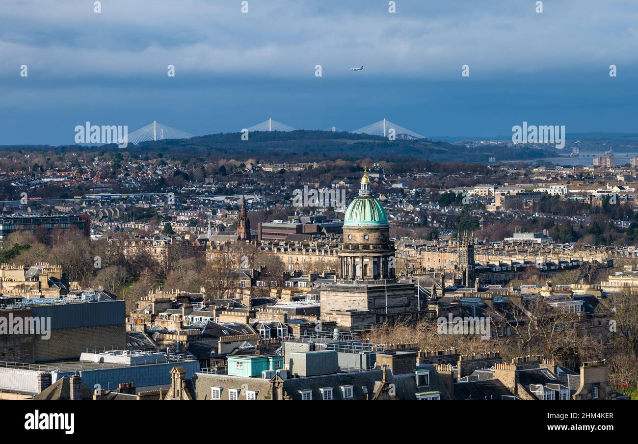 Edinburgh, Schottland, Großbritannien, 7th. Februar 2022. UK Wetter: Sonnenschein und Duschen. Die Hauptstadt leuchtet im Sonnenschein mit einem duschenden dunklen Himmel hinter der Queensferry Crossing-Brücke in der Ferne, wobei die Kupferkuppel des West Register House in der Stadtlandschaft herausragend ist Stockfoto