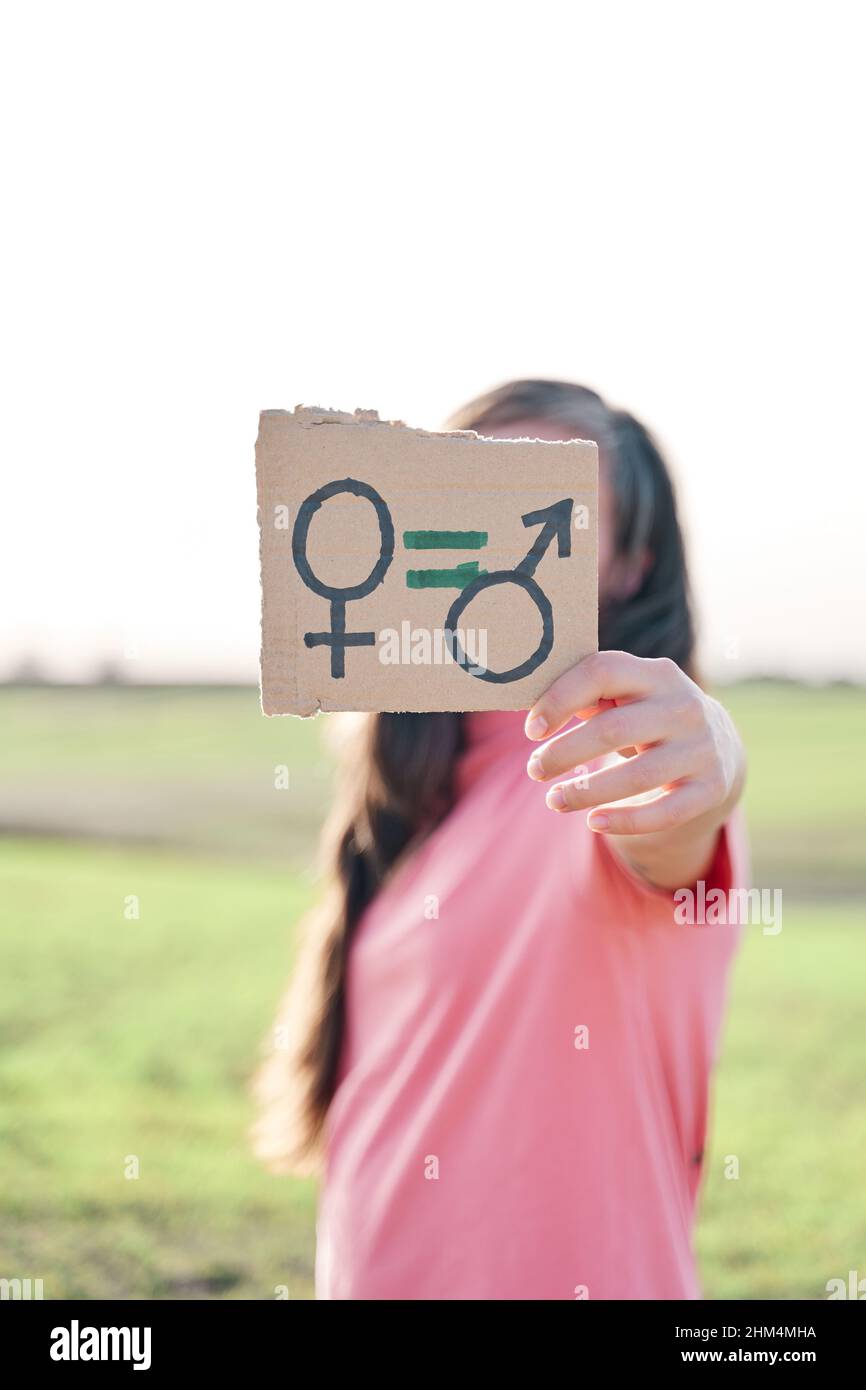 Frau, die einen Karton mit einem männlichen und weiblichen Symbol hält. Konzept der Gleichstellung der Geschlechter Stockfoto