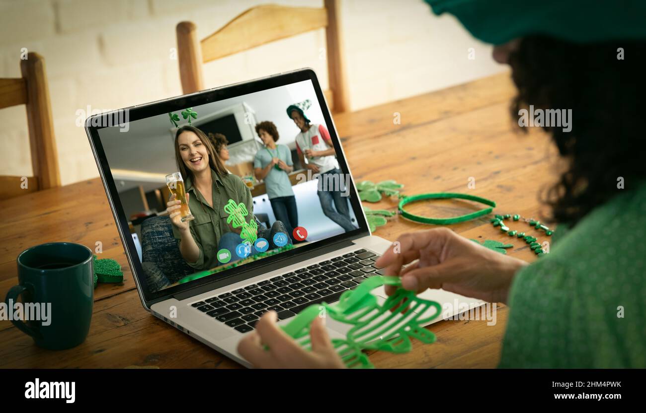 Kaukasische Frau, die eine Schamrock-Brille hält, während sie zu Hause einen Videoanruf auf dem Laptop führt Stockfoto