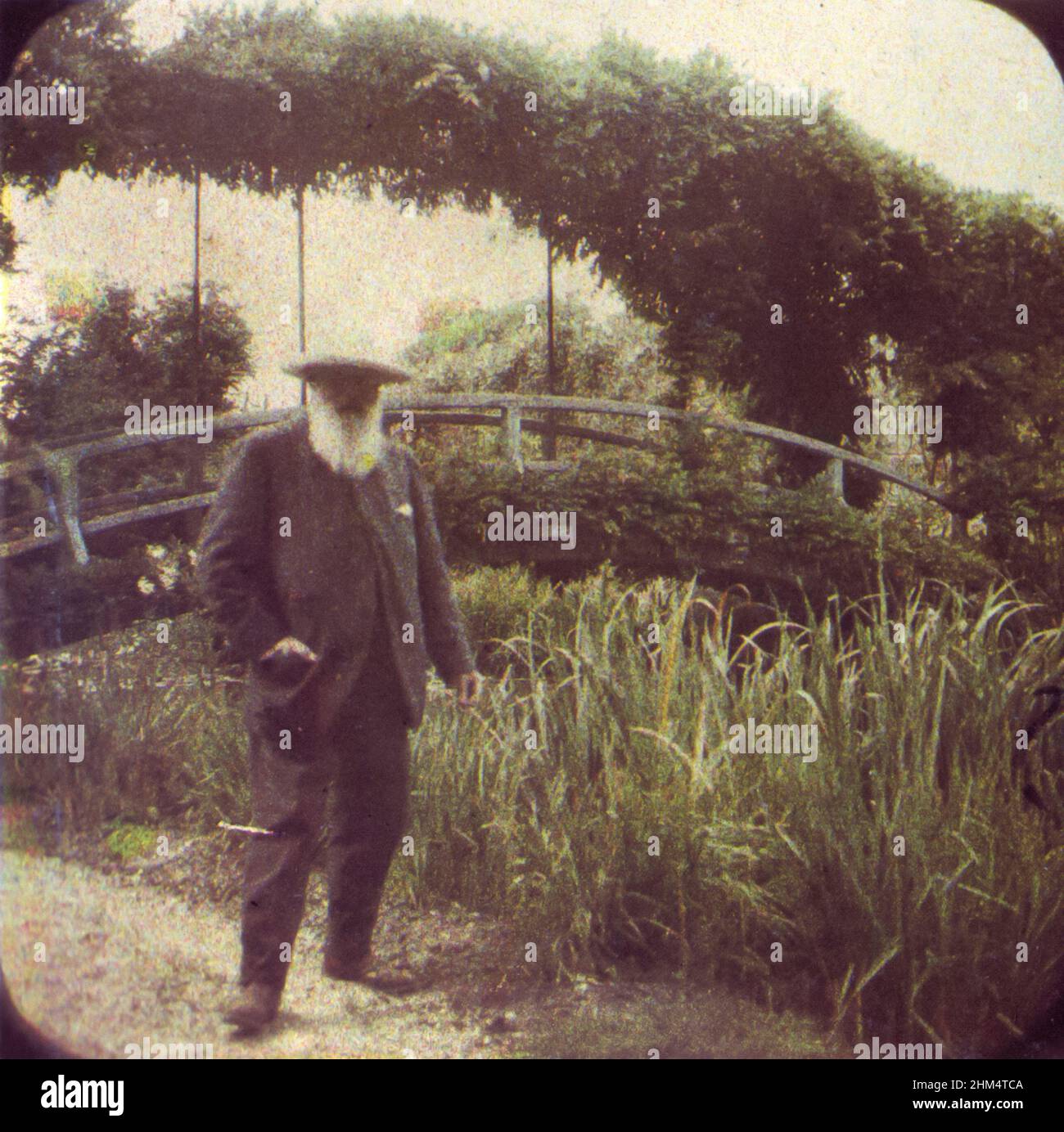 Claude Monet (1840-1926) der französische Impressionist, der 1917 in seinem Garten in Giverny, Frankreich, von Etienne Clémentel (1864-1936) mit dem von den Brüdern Lumière entwickelten Autochrome Lumière-Verfahren der Farbfotografie fotografiert wurde. Stockfoto