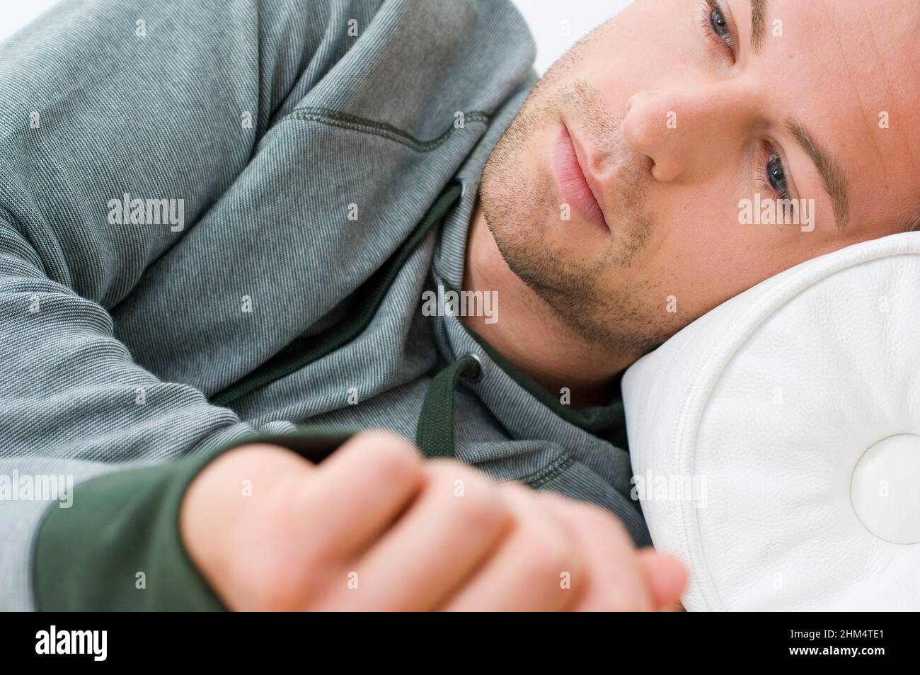 Nahaufnahme eines jungen Mannes, der auf dem Bett liegt und denkt, Credit:Photoshot Creative / Stuart Cox / Avalon Stockfoto