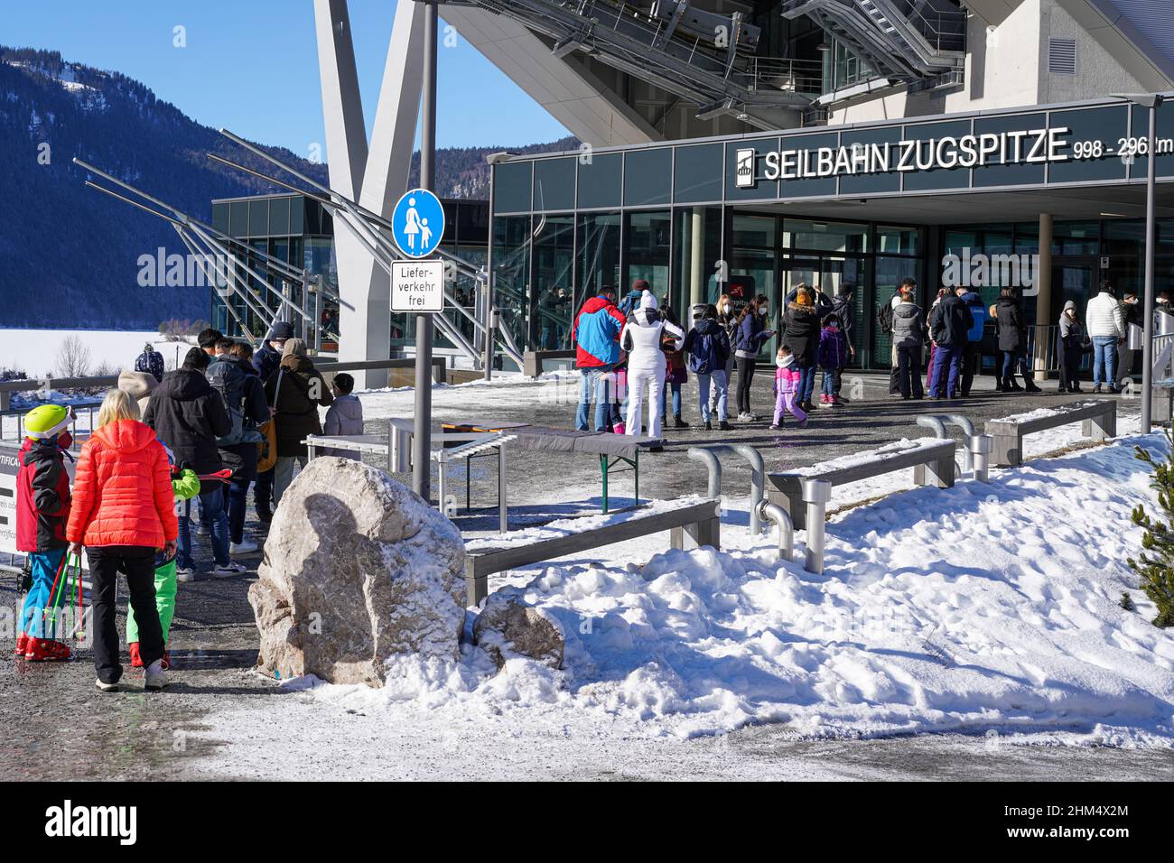 Zahlreiche Menschen warten auf den Eintritt zur Seilbahn auf die Zugspitze in den Alpen und müssen ihren Covid-Impfpass vorweisen Stockfoto