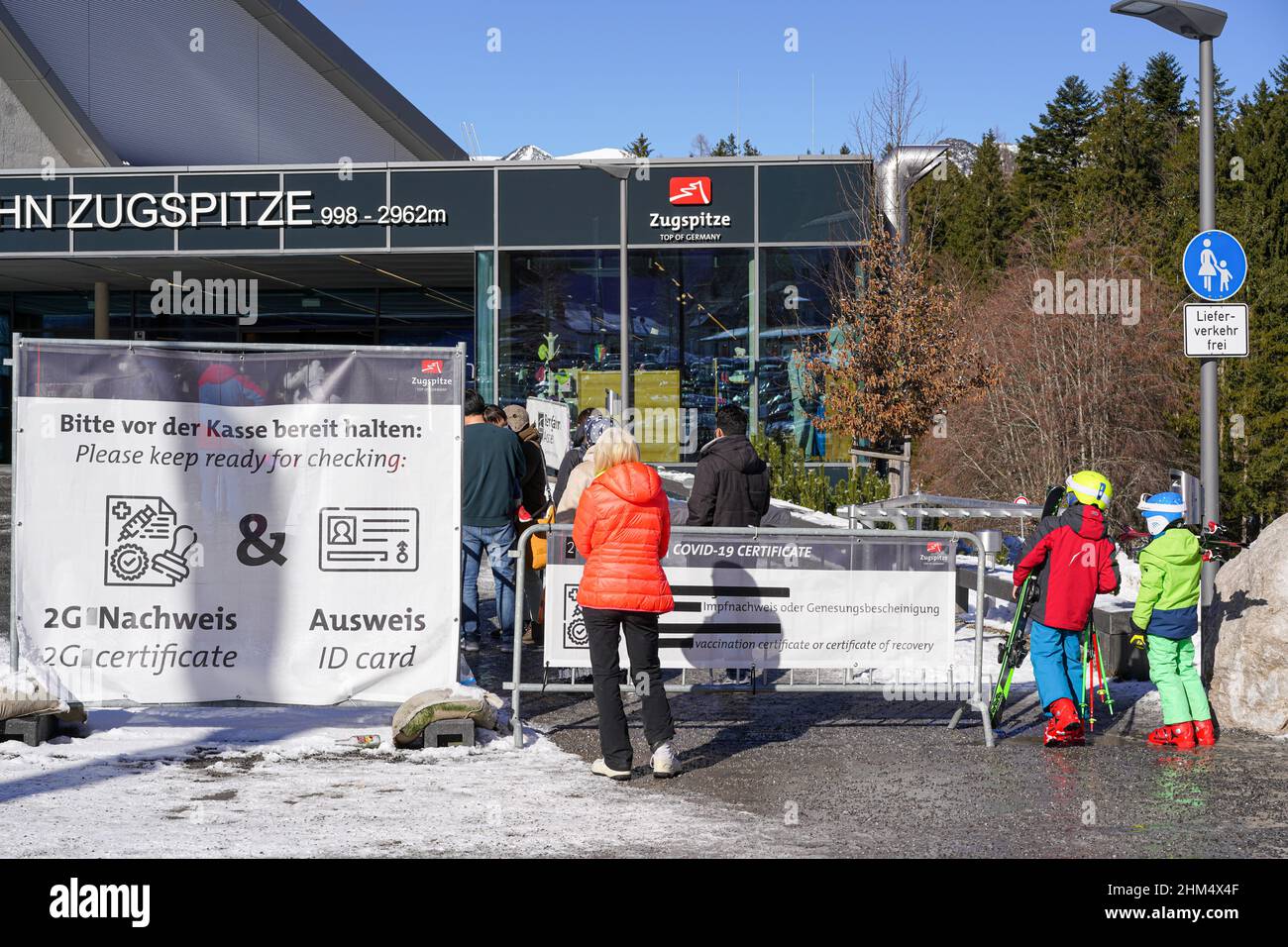 Zahlreiche Menschen warten auf den Eintritt zur Seilbahn auf die Zugspitze in den Alpen und müssen ihren Covid-Impfpass vorweisen Stockfoto