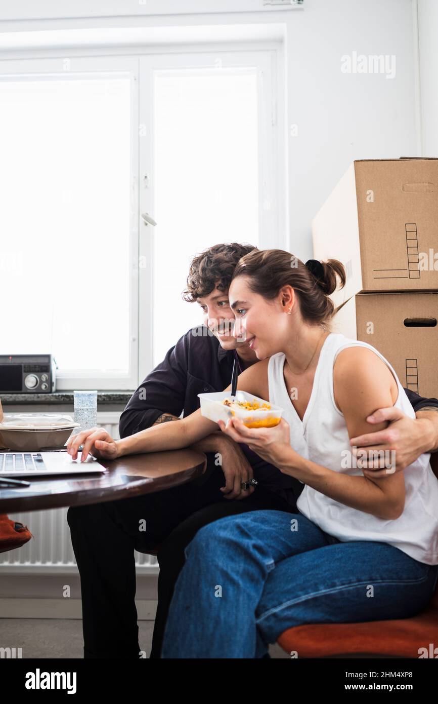 Paar essen zu Mittag und benutzen einen Laptop Stockfoto