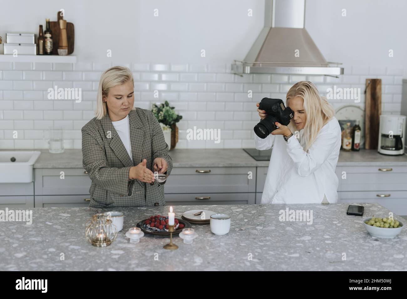 Frauen fotografieren Essen in der Küche Stockfoto