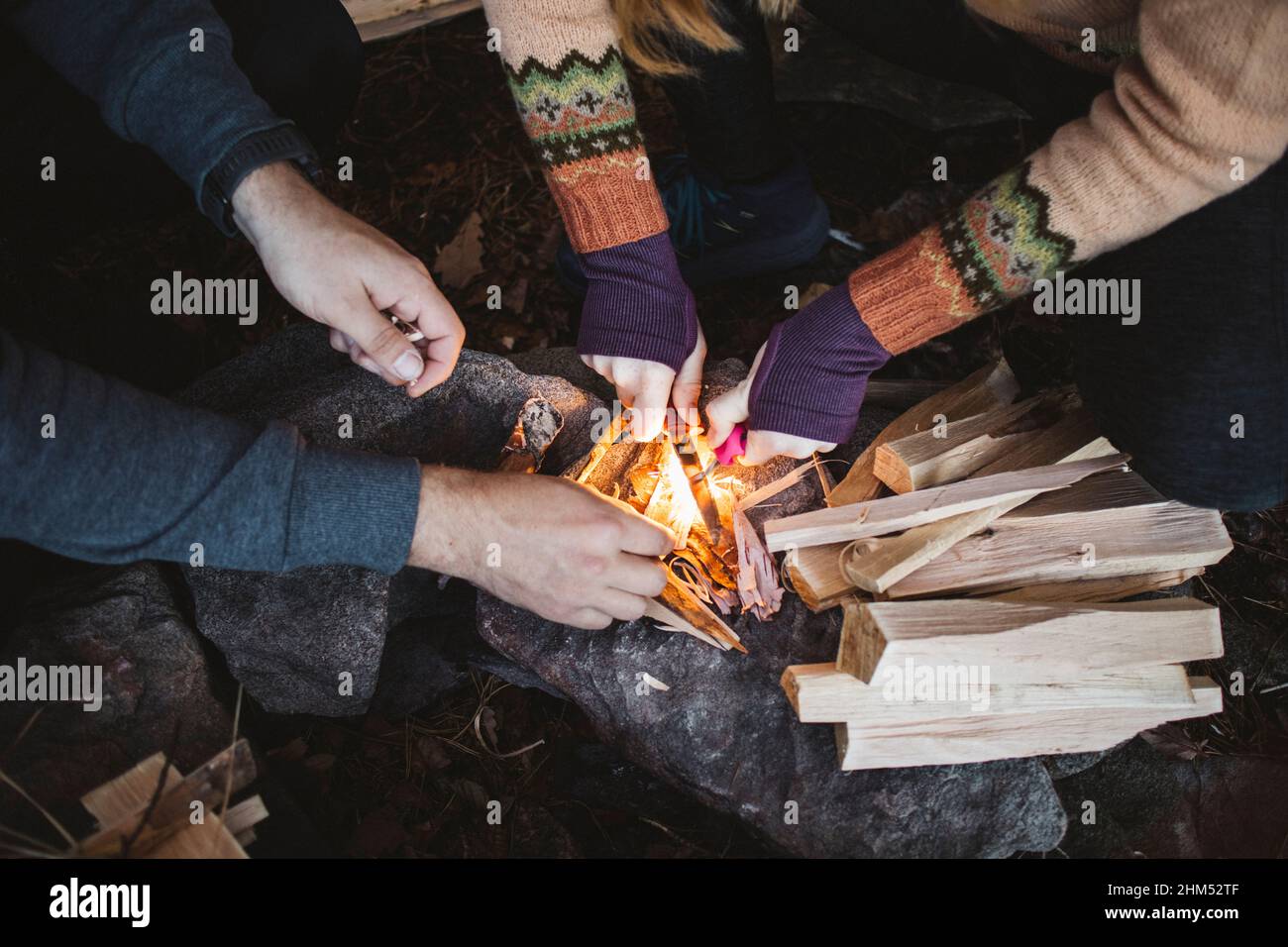 Menschen, die auf Felsen Lagerfeuer machen Stockfoto