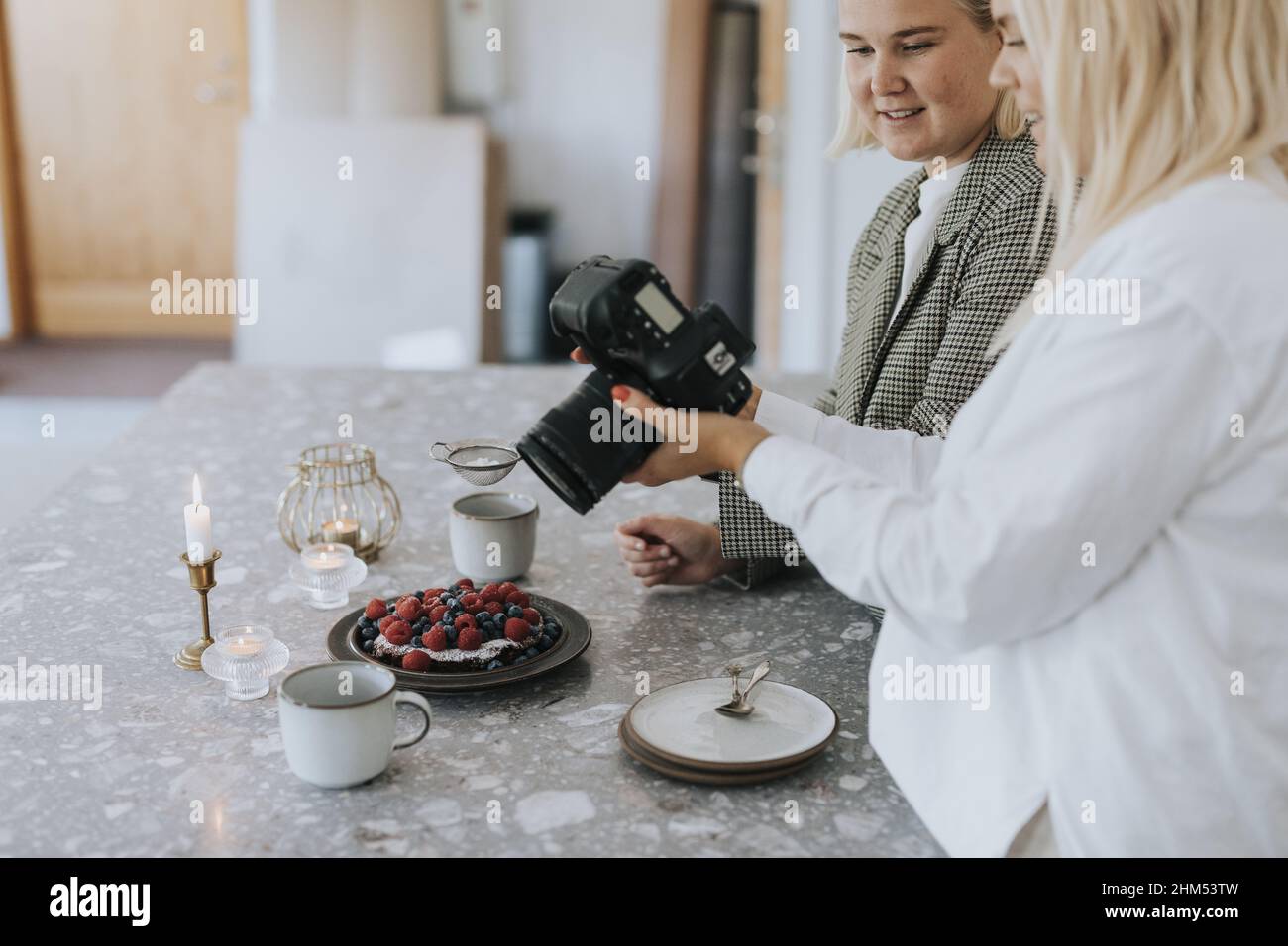 Frauen fotografieren Essen in der Küche Stockfoto