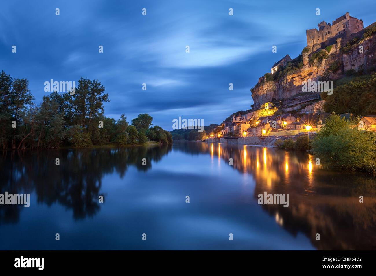 Chateau Beynac lange nach Sonnenuntergang mit dem Fluss Dordogne und Dorflichter, die sich im Wasser Beynac Dordogne France spiegeln Stockfoto