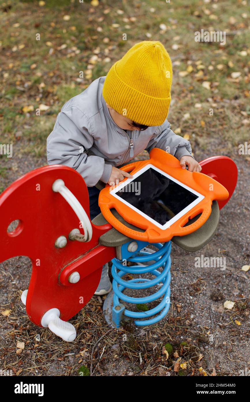 Kind auf dem Spielplatz mit digitalem Tablet Stockfoto