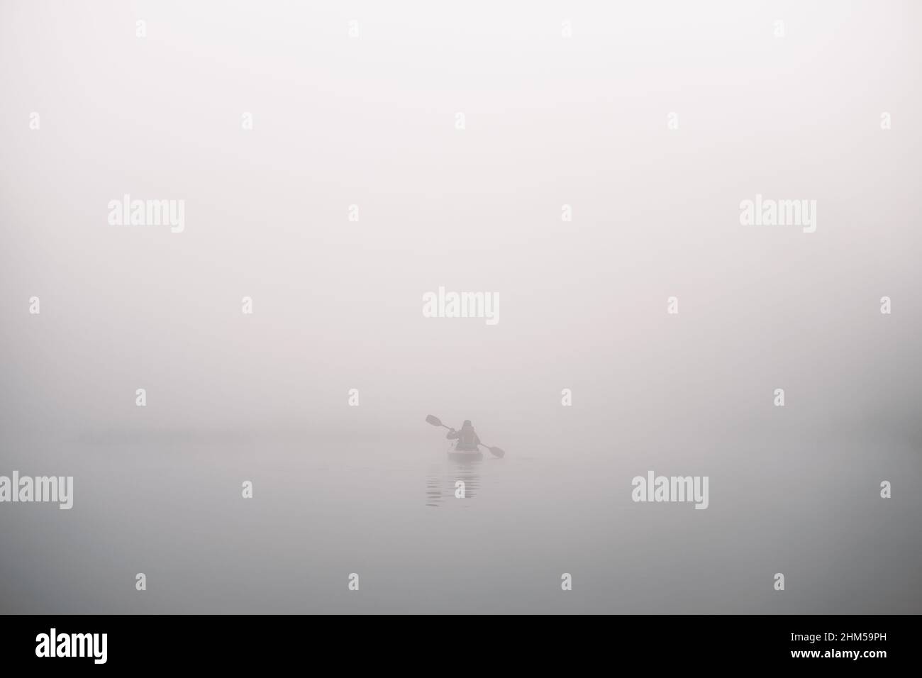 Ein Kajak-Boot in tiefem dichten Nebel, neblige Flusslandschaft Stockfoto