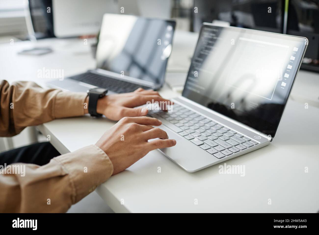 Hände von jungen, modernen Programmentwicklern, die im Büro oder im Büro auf der Laptop-Tastatur am Schreibtisch sitzen Stockfoto